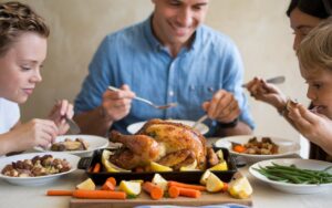 Family enjoying a wholesome wheat-free dinner with roasted chicken and vegetables